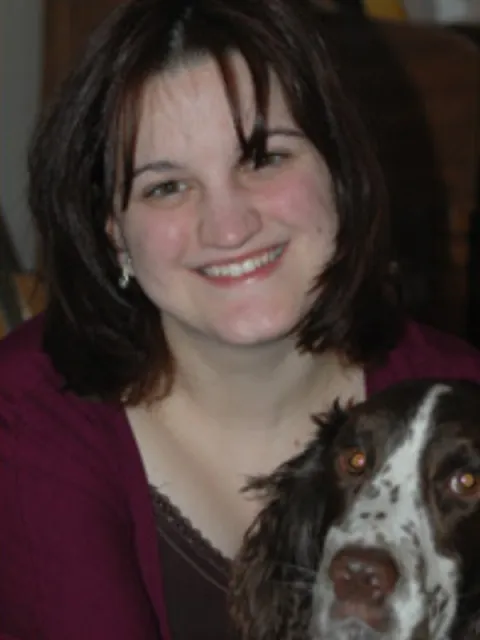 Dr. Jennifer Mateleska smiling with a spaniel