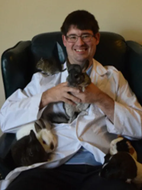 Dr. Michael Nystrom holding rabbits and guinea pigs